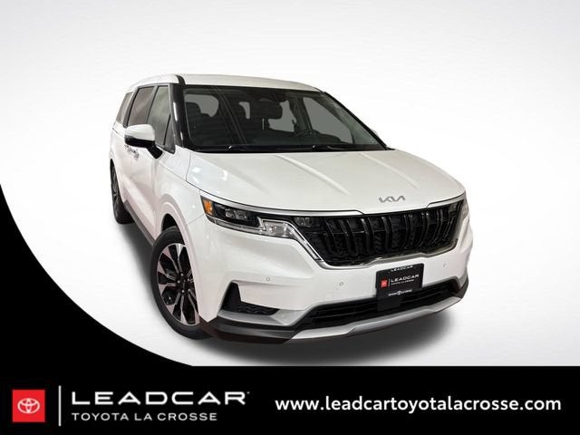 2024 Kia Carnival EX in Snow White Pearl — front three-quarter view